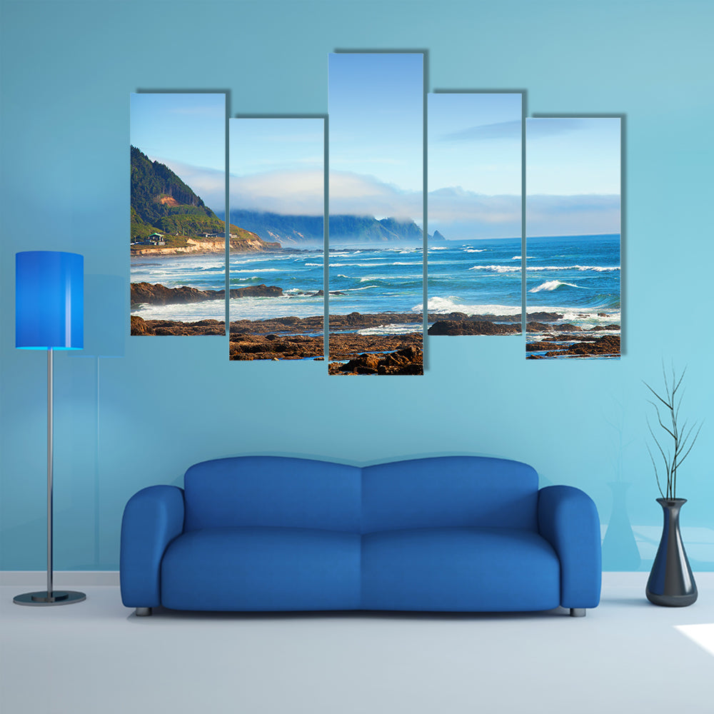 Rocky Shoreline with Crashing Waves and Misty Coastal Hills Canvas Wall Art