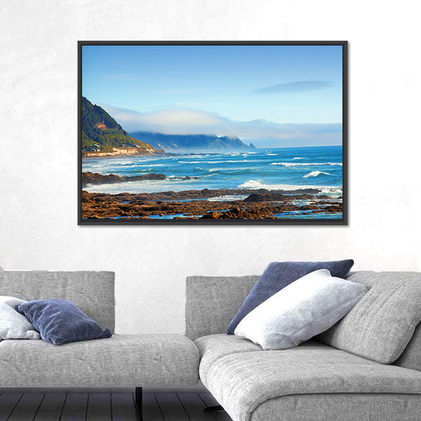 Rocky Shoreline with Crashing Waves and Misty Coastal Hills Canvas Wall Art
