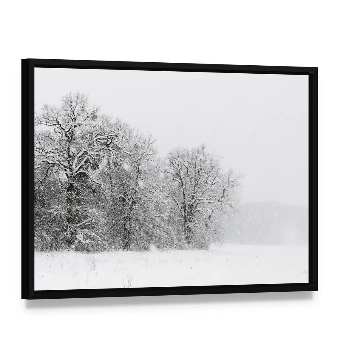 Minimalist Snowy Trees Canvas Wall Art, framed canvas in a black floater frame, angled product view