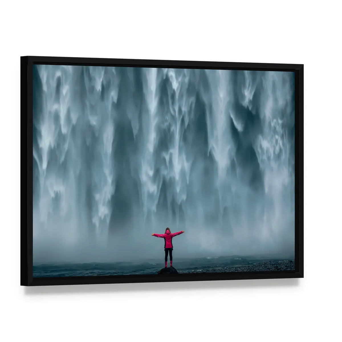 Girl Against Skogafoss Waterfall At South Iceland Canvas Wall Art, framed canvas in a black floater frame, angled product view