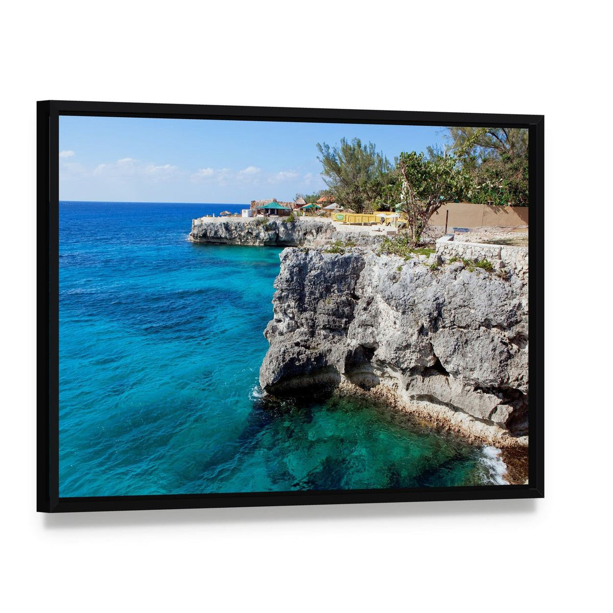Turquoise Ocean Cliffs with Tropical Vegetation Canvas Wall Art, framed canvas in a black floater frame, angled product view