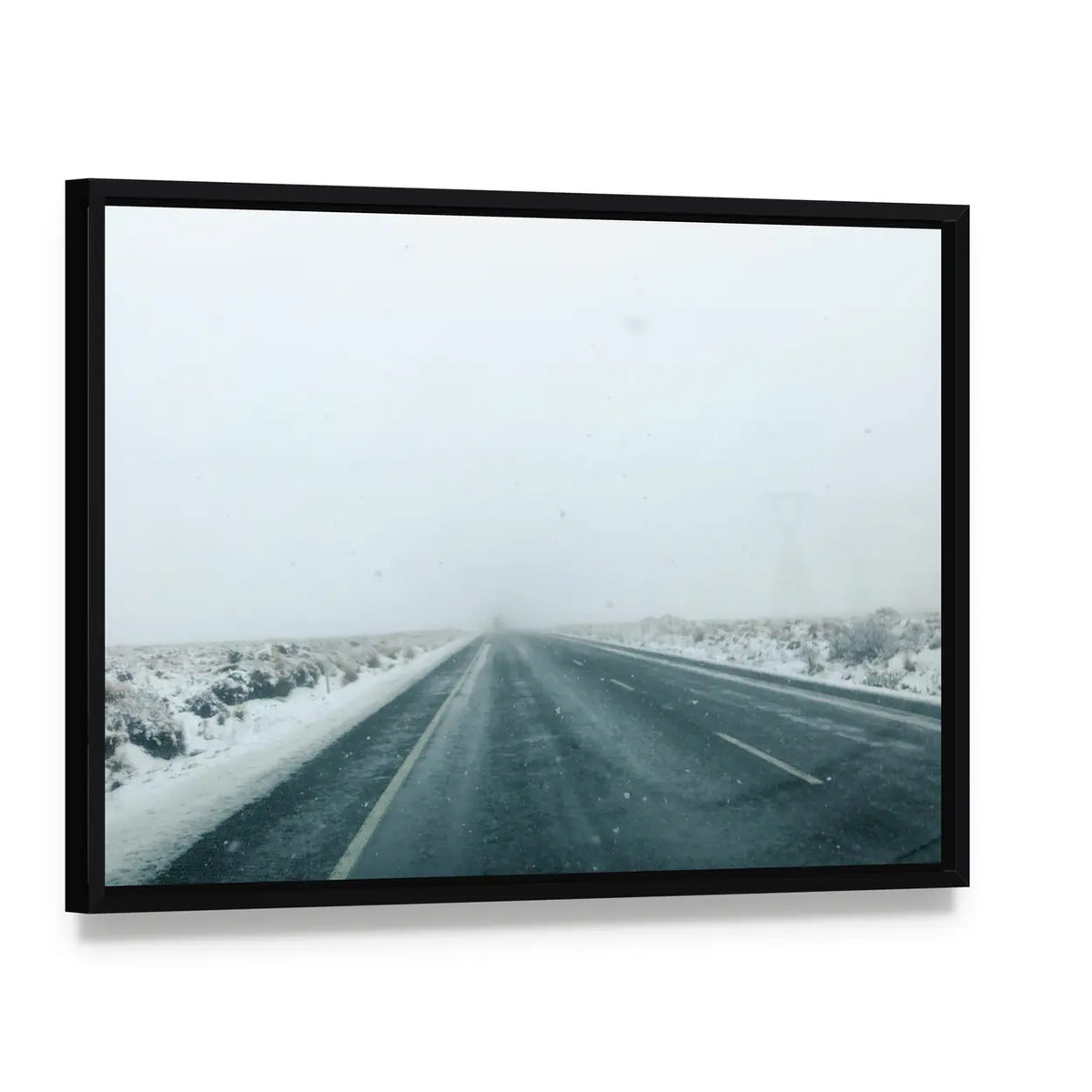 Mountain Road in Winter Storm Canvas Wall Art, framed canvas in a black floater frame, angled product view