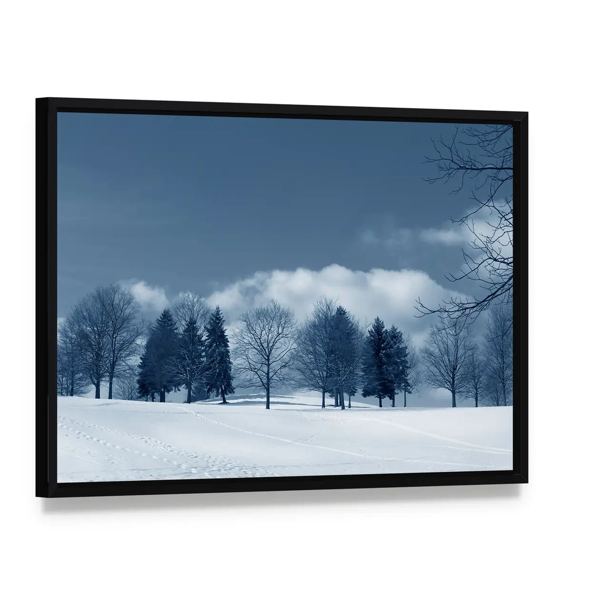 Snowy Field with Evergreens and Tracks Canvas Wall Art, framed canvas in a black floater frame, angled product view