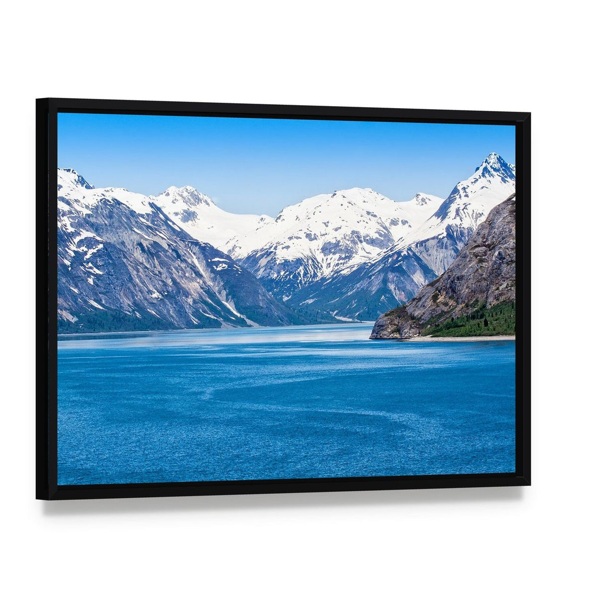 Snow-capped Mountains Over Calm Blue Water Canvas Wall Art, framed canvas in a black floater frame, angled product view
