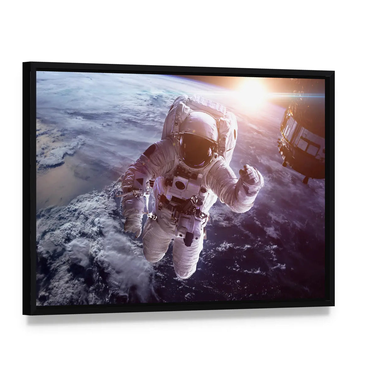 Astronaut Above the Earth Canvas Wall Art, framed canvas in a black floater frame, angled product view