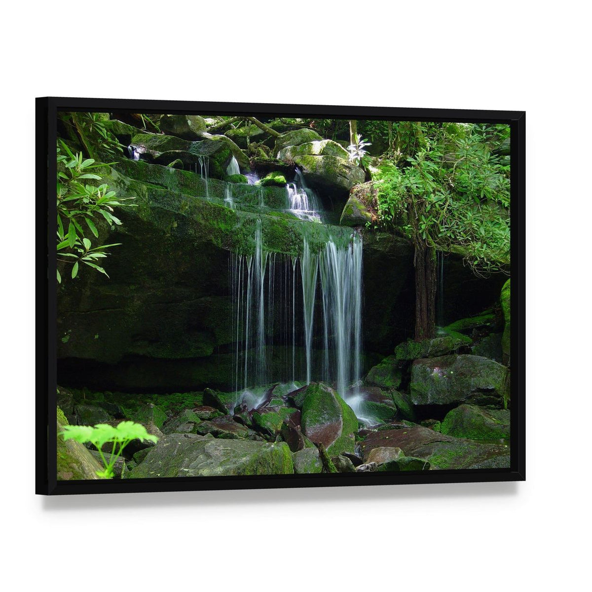 Waterfall Flows Over Moss-covered Rocks Canvas Wall Art, framed canvas in a black floater frame, angled product view