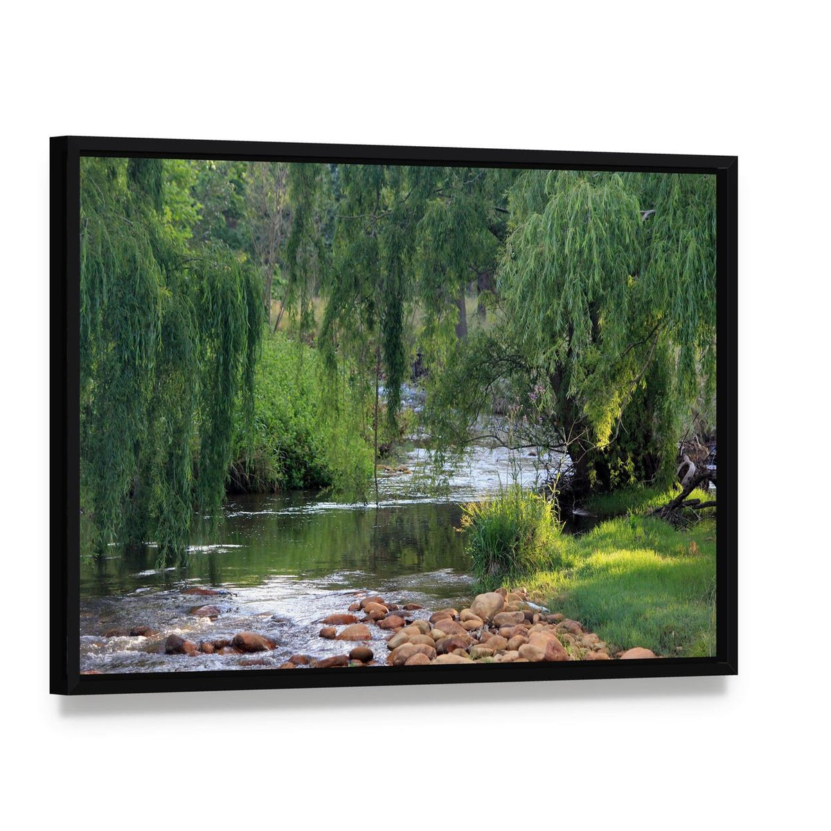River Flowing Past Willow Trees Canvas Wall Art, framed canvas in a black floater frame, angled product view