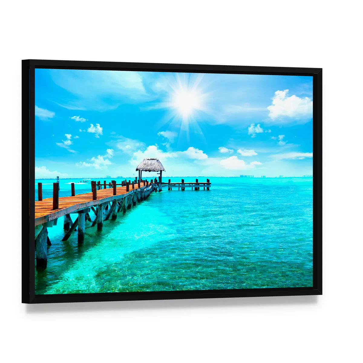 Sunlit Wooden Pier and Thatched Hut Canvas Wall Art, framed canvas in a black floater frame, angled product view