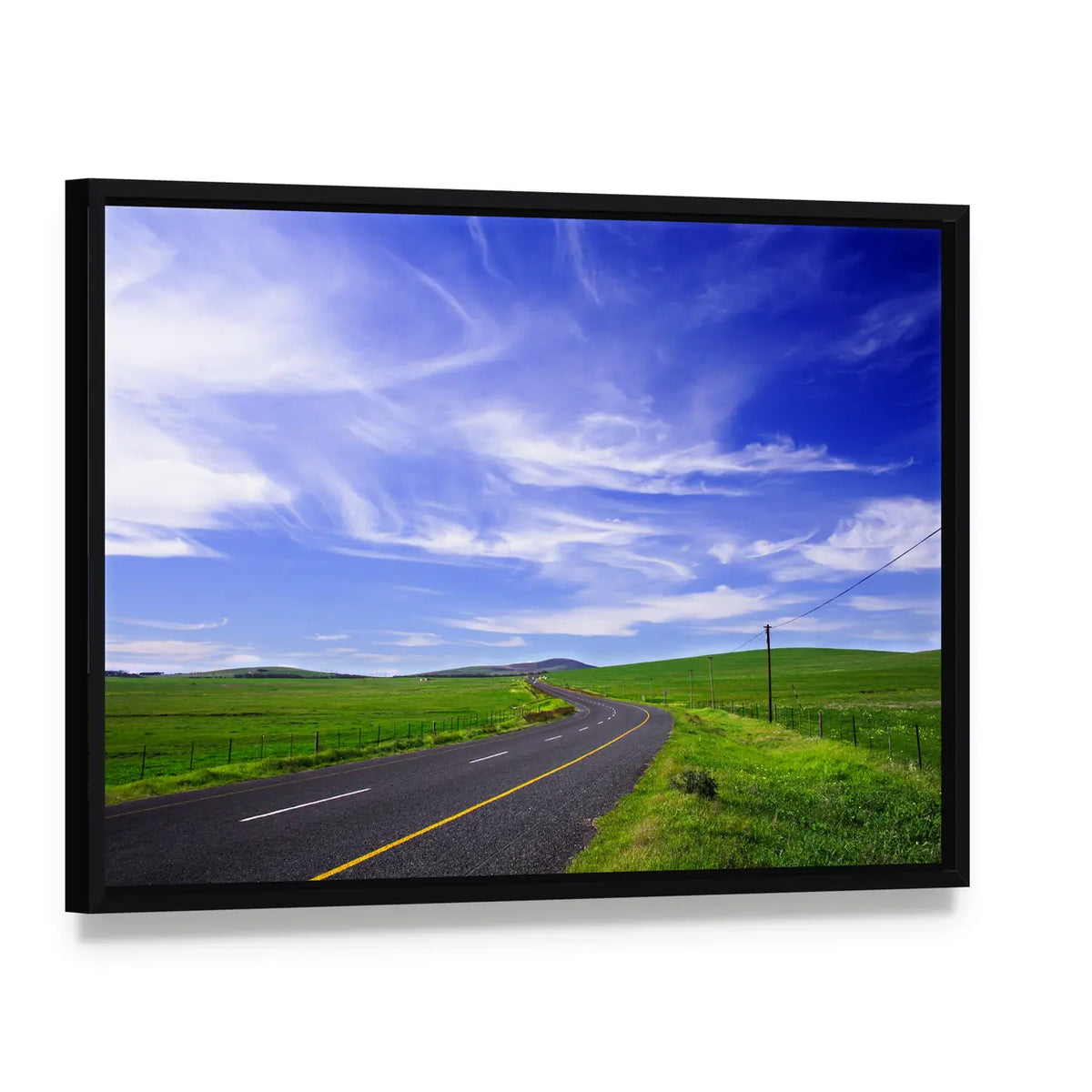 Winding Road Through Green Fields Canvas Wall Art, framed canvas in a black floater frame, angled product view