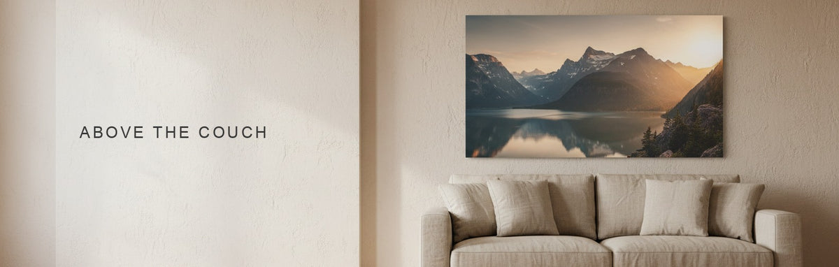 Wall art above a couch, a wide horizontal landscape canvas centered above the cushions