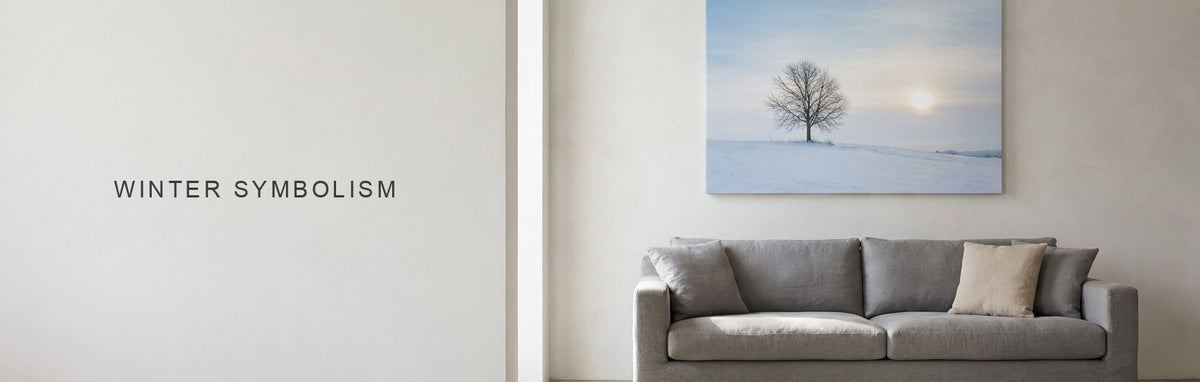 Winter symbolism, a lone bare tree on a snowy hill under a low winter sun, on canvas above a gray sofa