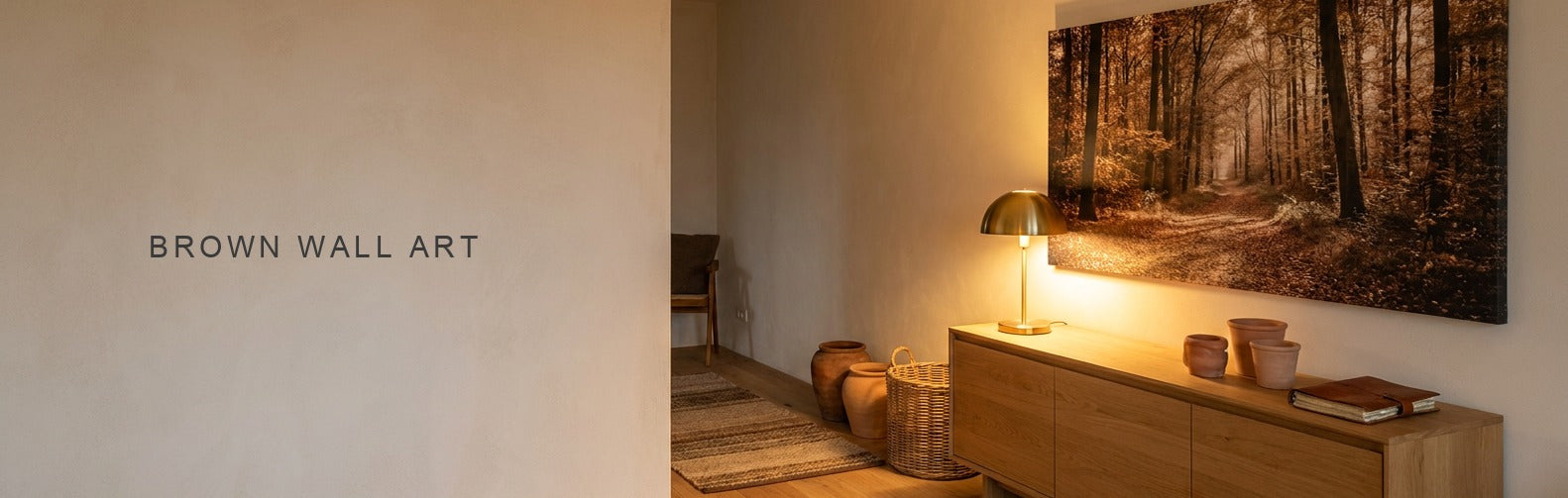 Brown wall art in a warm lamplit room, an autumn forest path canvas
