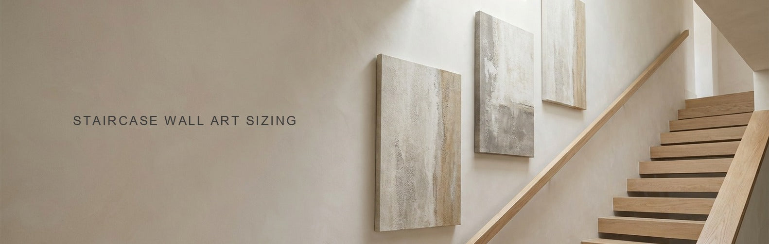 Staircase wall art: three vertical canvases stepped up a stairwell wall parallel to the handrail