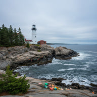 Maine Wall Art canvas print, a white lighthouse on granite ledges above a cold blue Atlantic with pines and lobster buoys