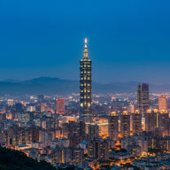 Taipei Wall Art canvas print, the tiered pagoda-like supertall tower lit at dusk above the city with green mountains behind