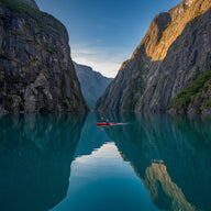 Kayaking Wall Art canvas print, a kayaker on still turquoise water between steep fjord walls