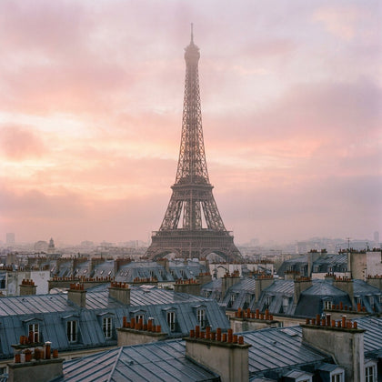 Paris Wall Art canvas print, the Eiffel Tower rising above zinc mansard rooftops and chimney pots at soft pink dawn