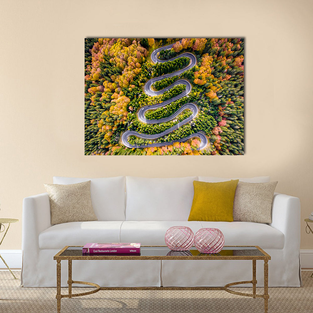 Autumn Winding Road In The Forest Canvas Wall Art in orange, yellow and green, single panel hung on a wall
