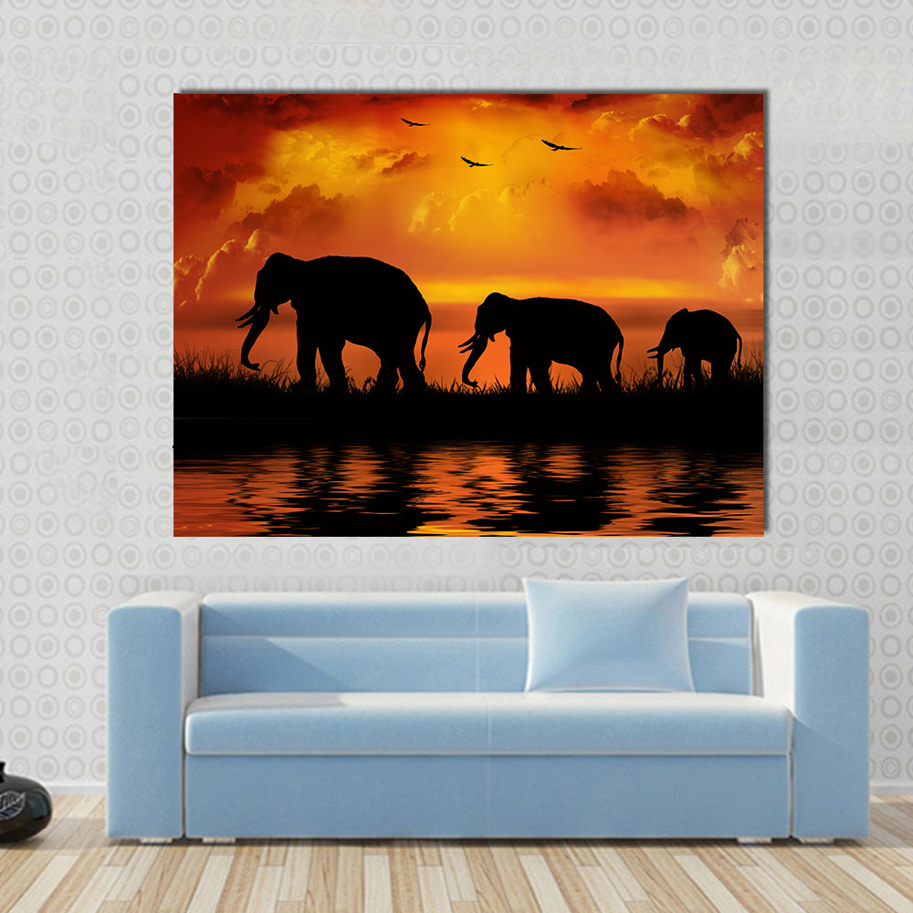 Three Elephants at Sunset Canvas Wall Art in black, orange and yellow, single panel hung on a wall