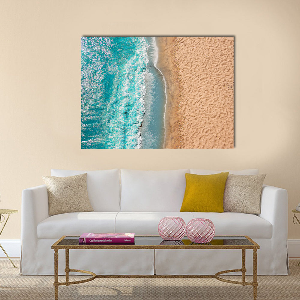 Coastline Beach Ocean Waves With Foam On The Sand Canvas Wall Art in white, beige and blue, single panel hung on a wall