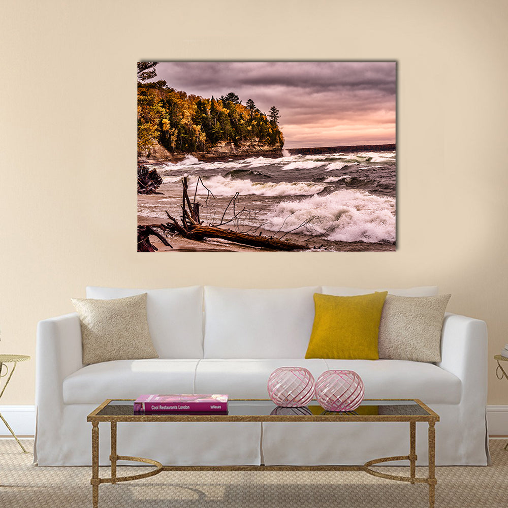 Driftwood on Autumn Lakeshore Canvas Wall Art in gray, brown and orange, single panel hung on a wall
