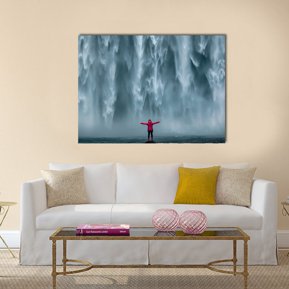 Girl Against Skogafoss Waterfall At South Iceland Canvas Wall Art in white, gray and blue, single panel hung on a wall
