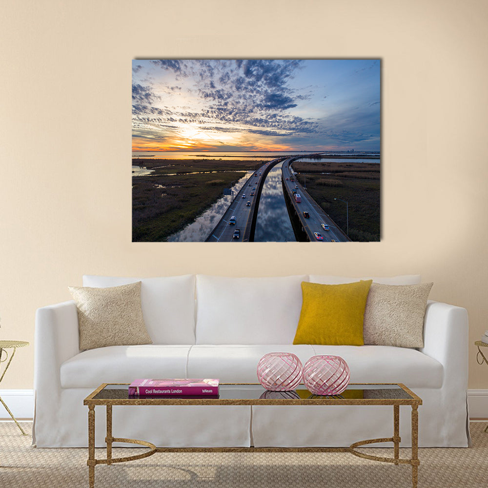 Sunset Over Highway Bridge Canvas Wall Art in orange, yellow and blue, single panel hung on a wall