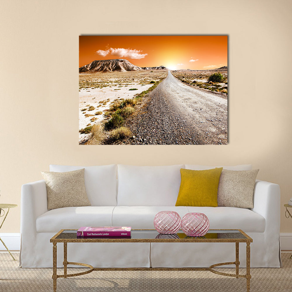 Sunset Desert Road Landscape Canvas Wall Art in beige, brown and orange, single panel hung on a wall