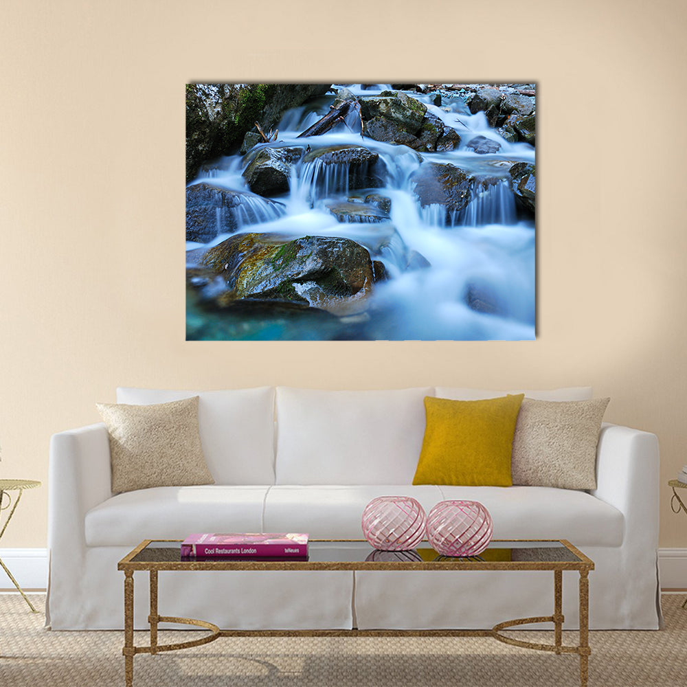 River Through Mossy Stones in Cadore Canvas Wall Art in gray, brown and blue, single panel hung on a wall