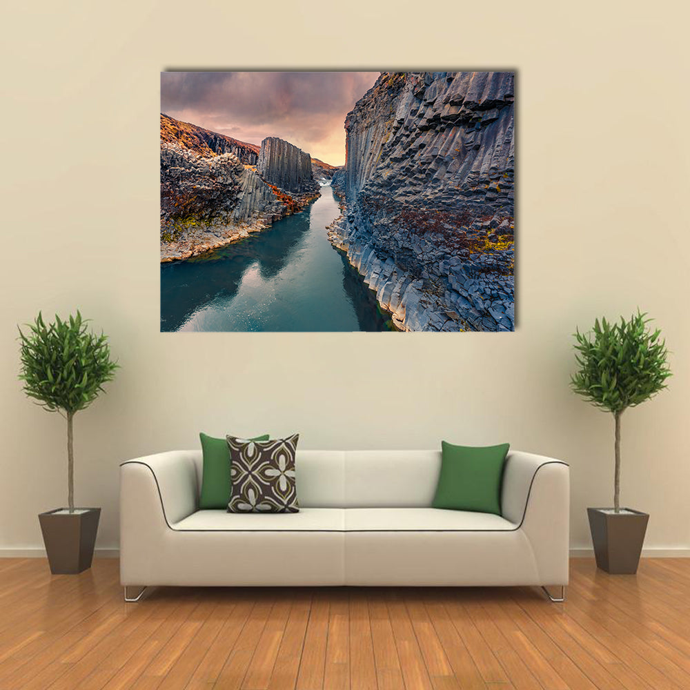 Studlagil Canyon In Iceland Canvas Wall Art in gray, orange and blue, single panel hung on a wall