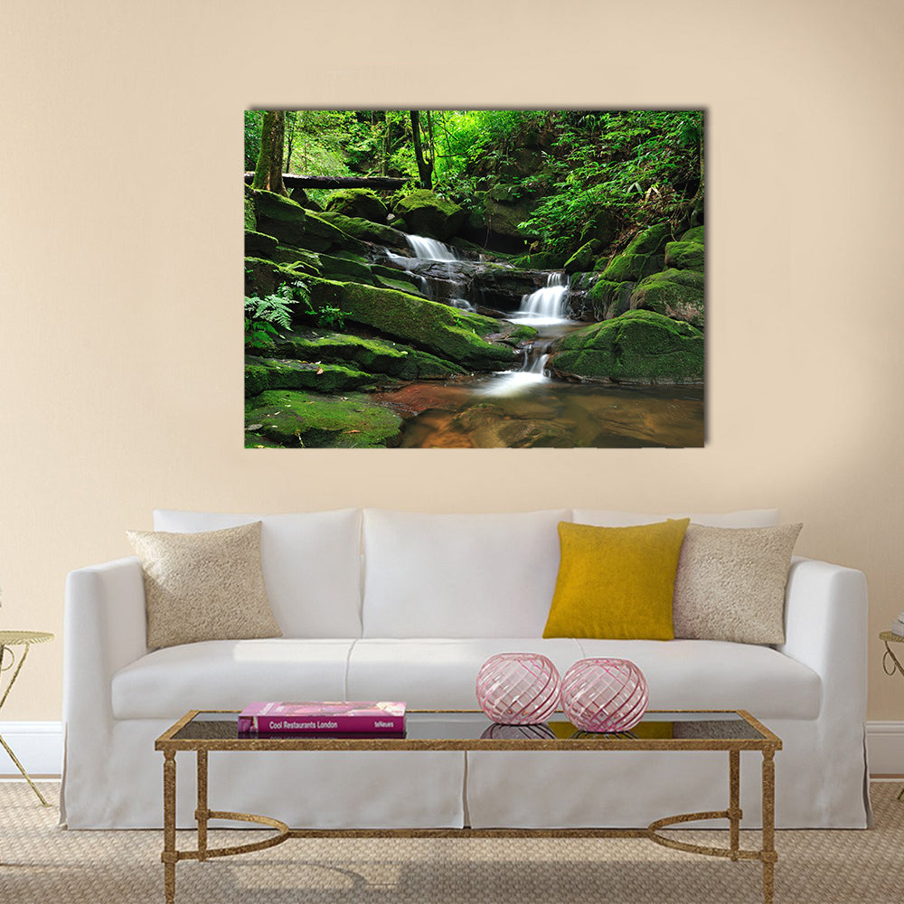 Waterfall In Rain Forest Canvas Wall Art in white, brown and green, single panel hung on a wall