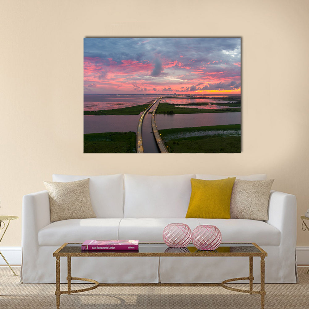 Sunset Over Coastal Bridge Canvas Wall Art in orange, blue and pink, single panel hung on a wall