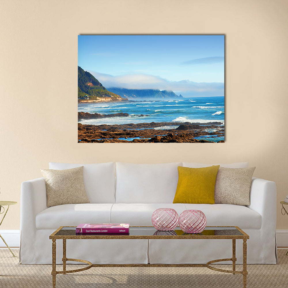 Rocky Shoreline with Crashing Waves and Misty Coastal Hills Canvas Wall Art