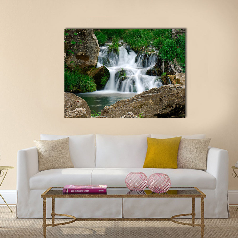 Small Forest Waterfall Canvas Wall Art in white, brown and green, single panel hung on a wall