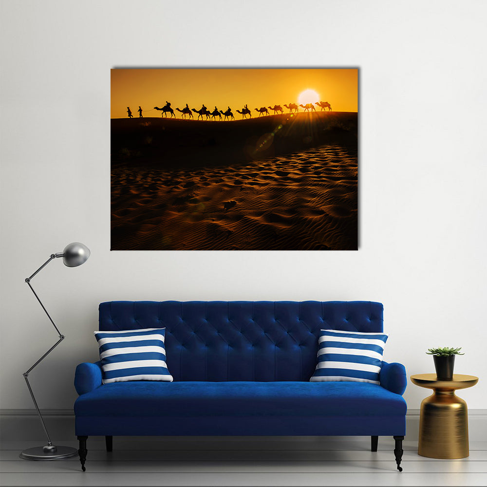 Camel Caravan at Sunset Canvas Wall Art in black, orange and yellow, single panel hung on a wall