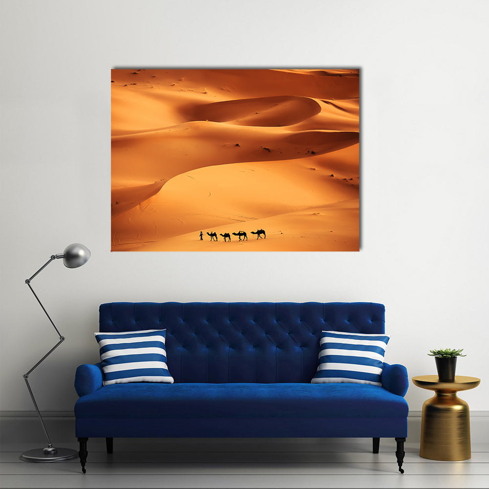 Camel Caravan Across Sahara Sand Dunes Canvas Wall Art in brown, orange and yellow, single panel hung on a wall