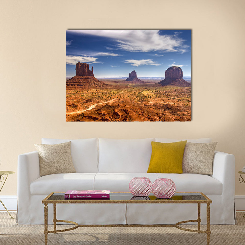 Monument Valley Buttes in Warm Desert Light Canvas Wall Art in brown, orange and blue, single panel hung on a wall