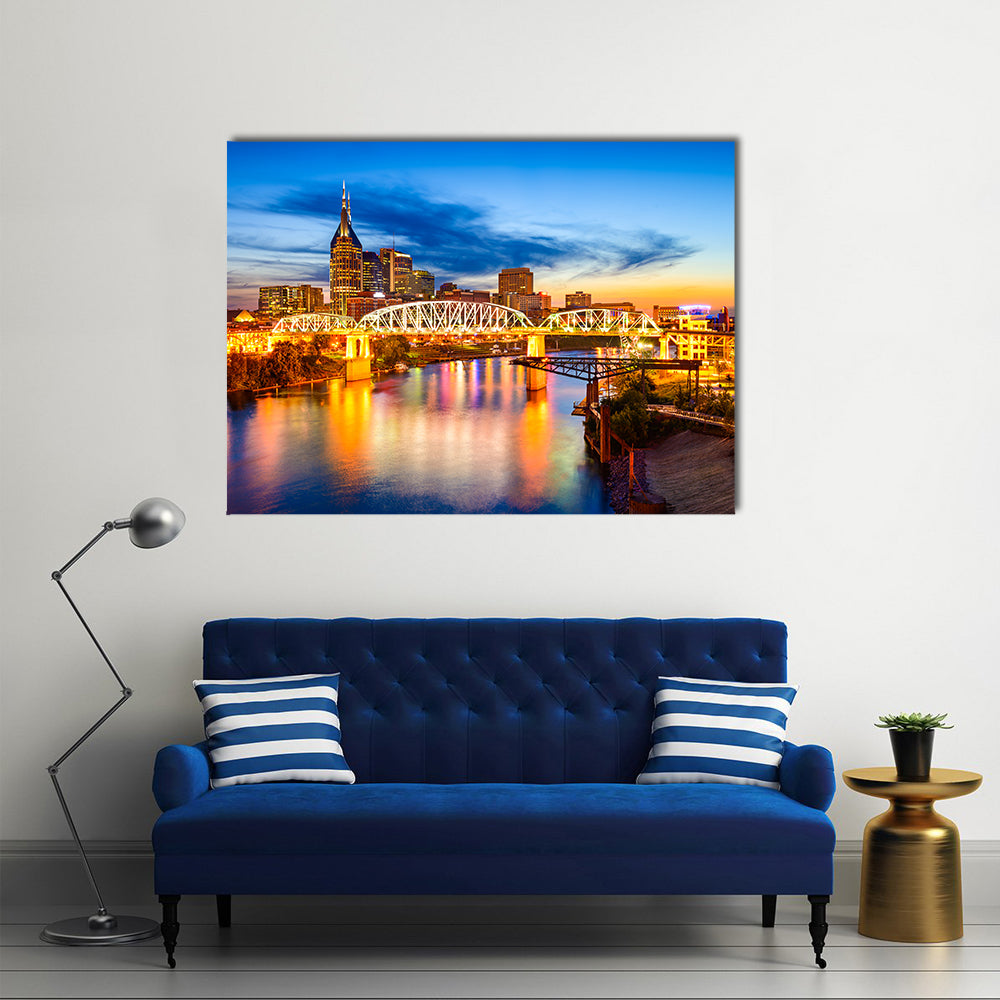 Nashville Skyline with Pedestrian Bridge at Dusk Canvas Wall Art in orange, yellow and blue, single panel hung on a wall