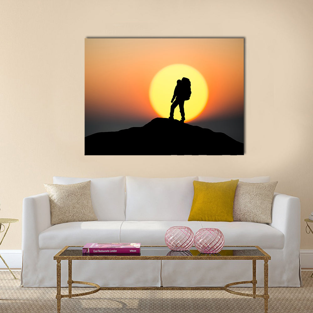 Silhouette Of Rock Climber On The Peak Canvas Wall Art in black, orange and yellow, single panel hung on a wall