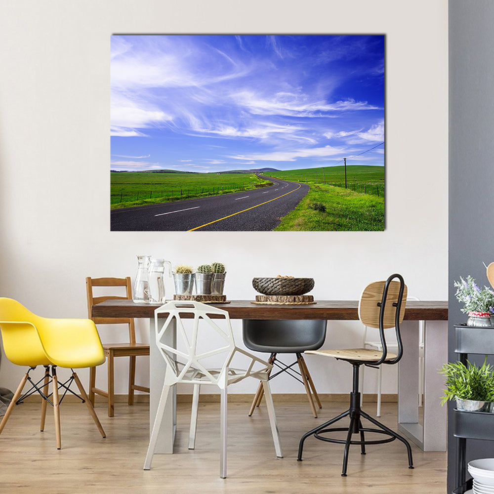 Winding Road Through Green Fields Canvas Wall Art in black, green and blue, single panel hung on a wall