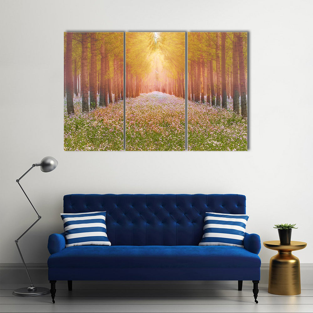Sunlit Forest Path with Wildflowers Canvas Wall Art in yellow, green and pink, 3 panel horizontal set hung on a wall