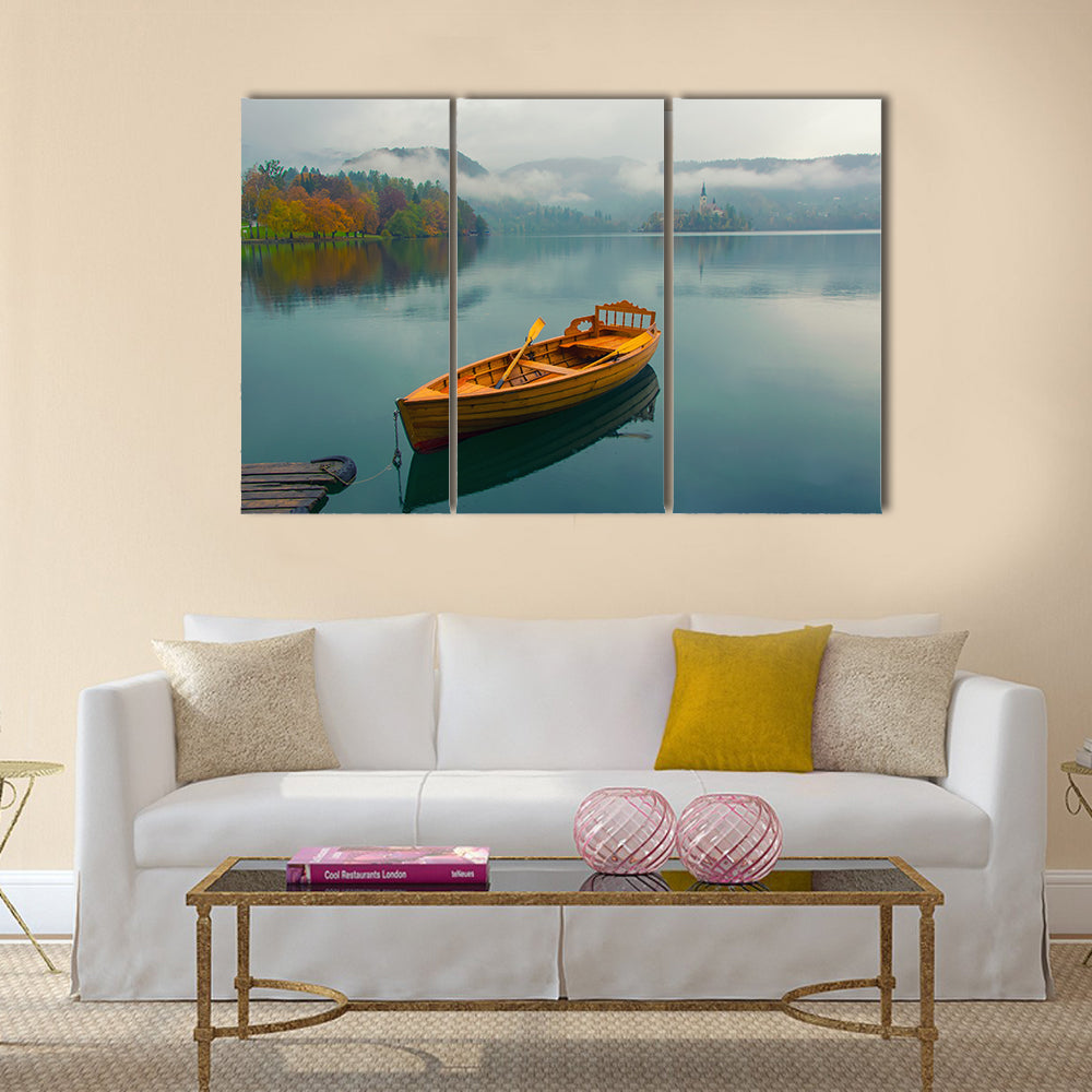 Lonely Boat on Lake Bled Canvas Wall Art in brown, green and blue, 3 panel horizontal set hung on a wall