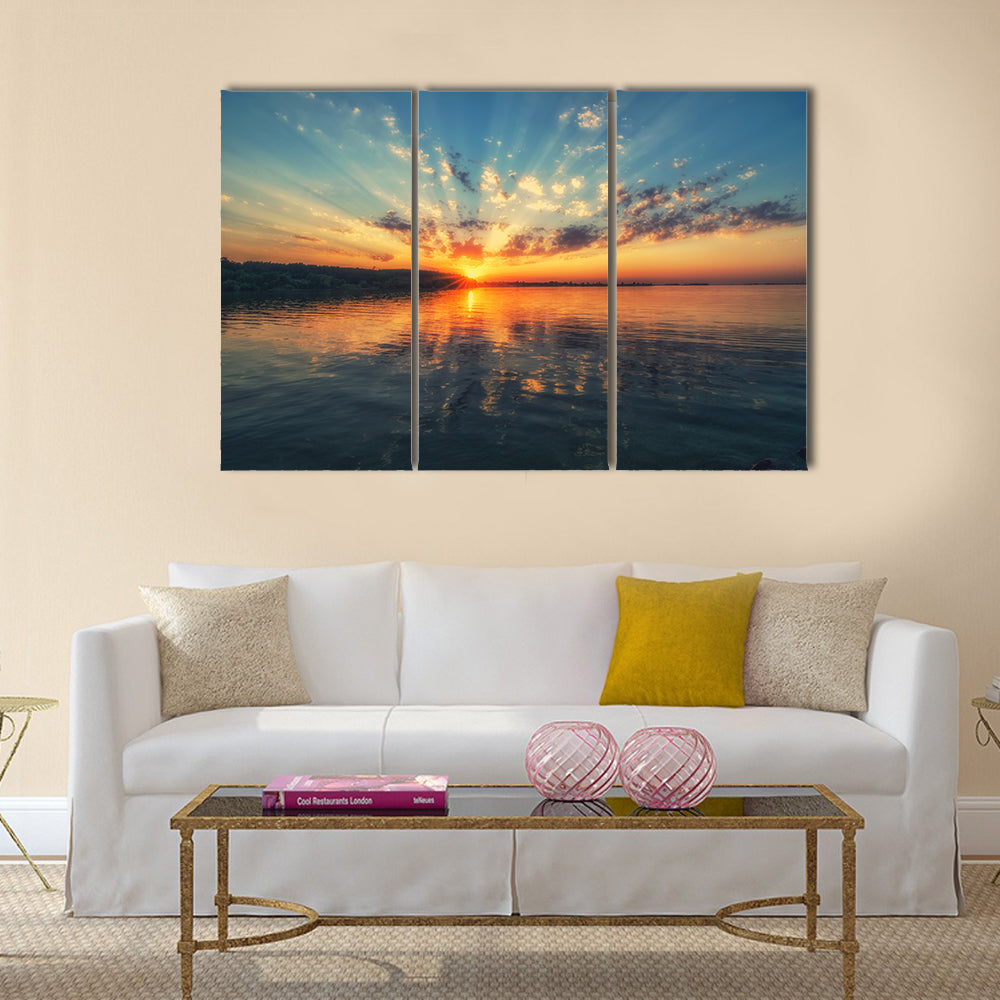 Sunset River with Rippling Reflection Canvas Wall Art in orange, yellow and blue, 3 panel horizontal set hung on a wall