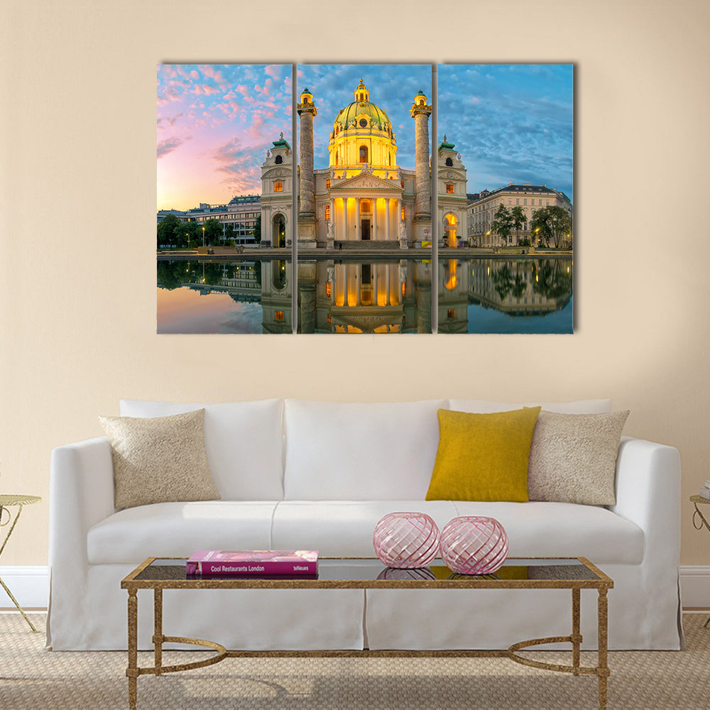 St. Charles Church Sunset Reflection Canvas Wall Art in orange, yellow and blue, 3 panel horizontal set hung on a wall