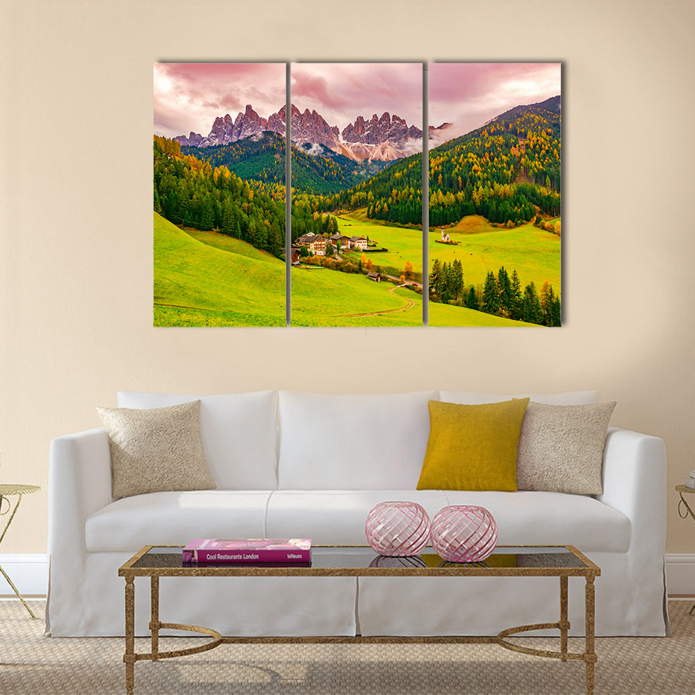 Santa Maddalena Village at Autumn Twilight Canvas Wall Art in yellow, green and pink, 3 panel horizontal set hung on a wall