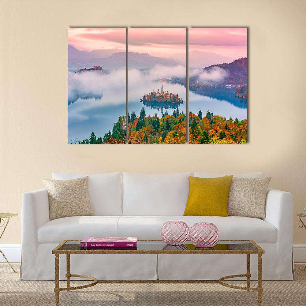 Lake Bled at Sunrise Canvas Wall Art in orange, blue and pink, 3 panel horizontal set hung on a wall