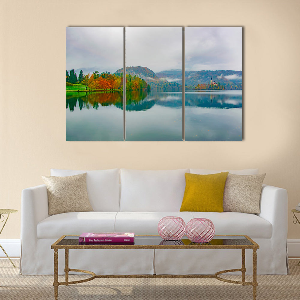 Autumn at Bled Lake, Slovenia Canvas Wall Art in gray, orange and blue, 3 panel horizontal set hung on a wall