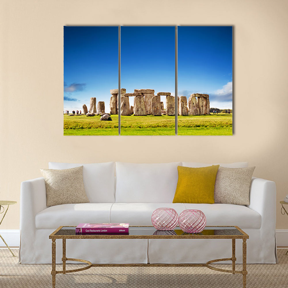 Stonehenge Stone Circle in England Canvas Wall Art in gray, green and blue, 3 panel horizontal set hung on a wall