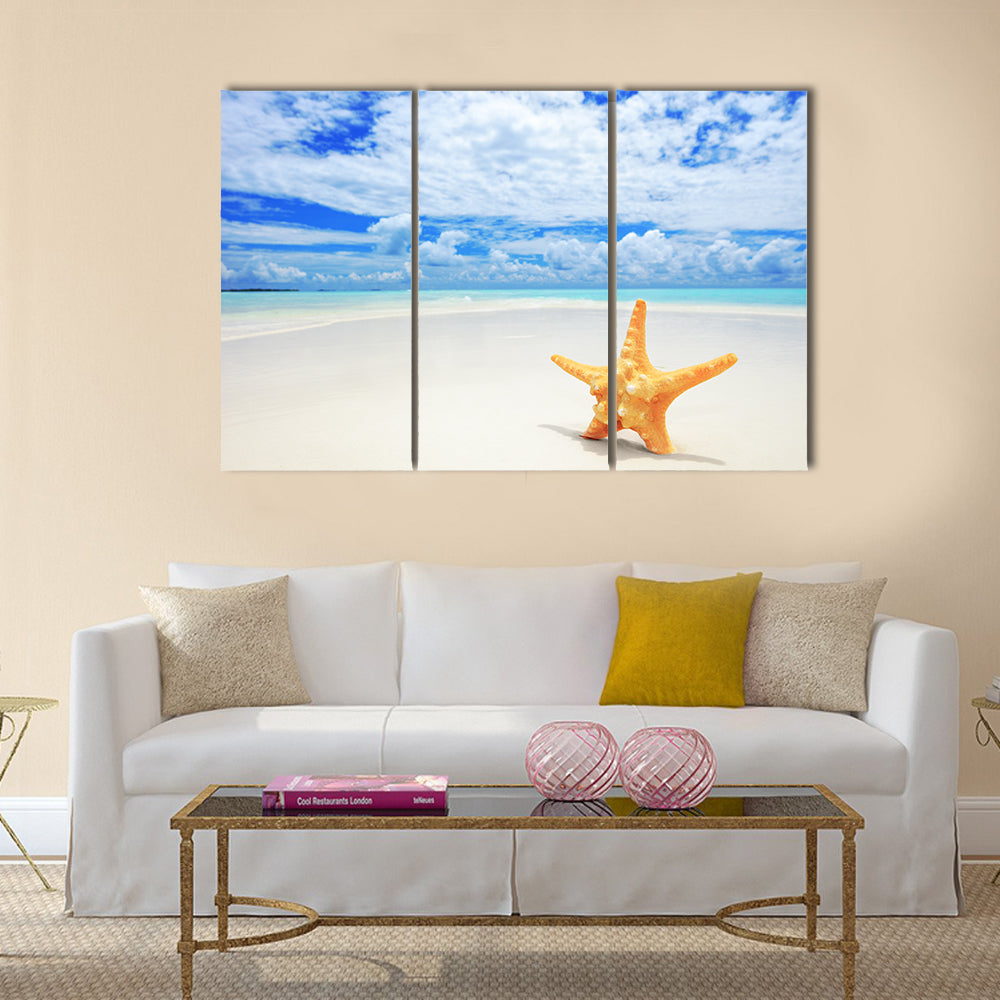 Starfish on Kuredu Island Beach Canvas Wall Art in white, beige and blue, 3 panel horizontal set hung on a wall