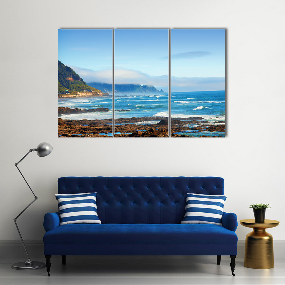Rocky Shoreline with Crashing Waves and Misty Coastal Hills Canvas Wall Art